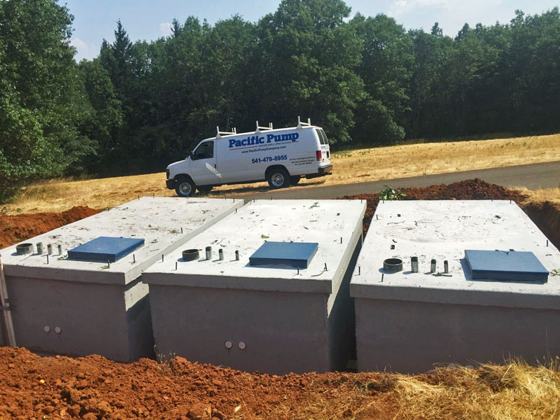Pacific Pump Work Van parked behind 3 water holding tanks